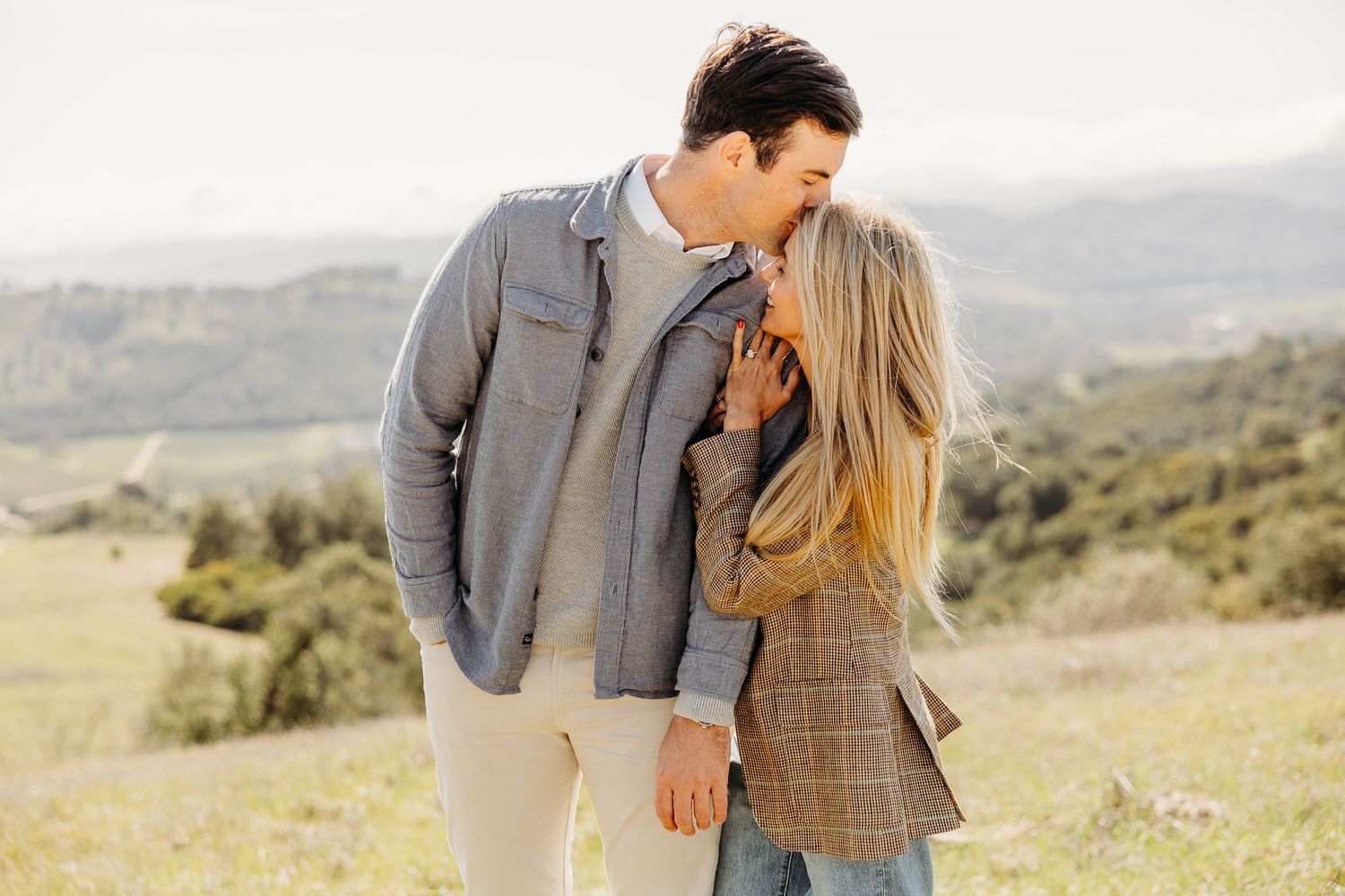 A romantic sequence of photos captured in a sunny meadow with rolling hills in the background.