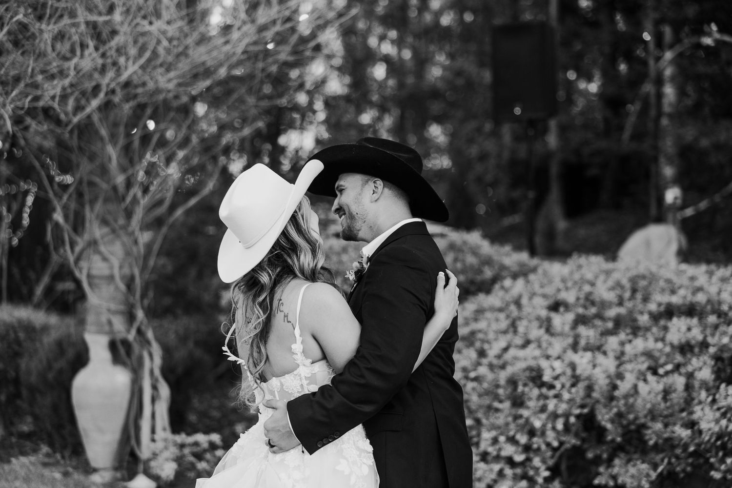 A black and white wedding photoshoot captured in an outdoor garden setting.