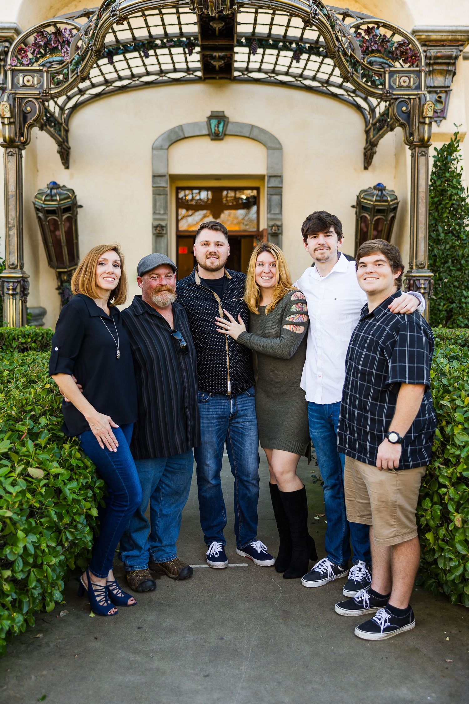 Group photo beneath an ornate architectural archway with decorative details.