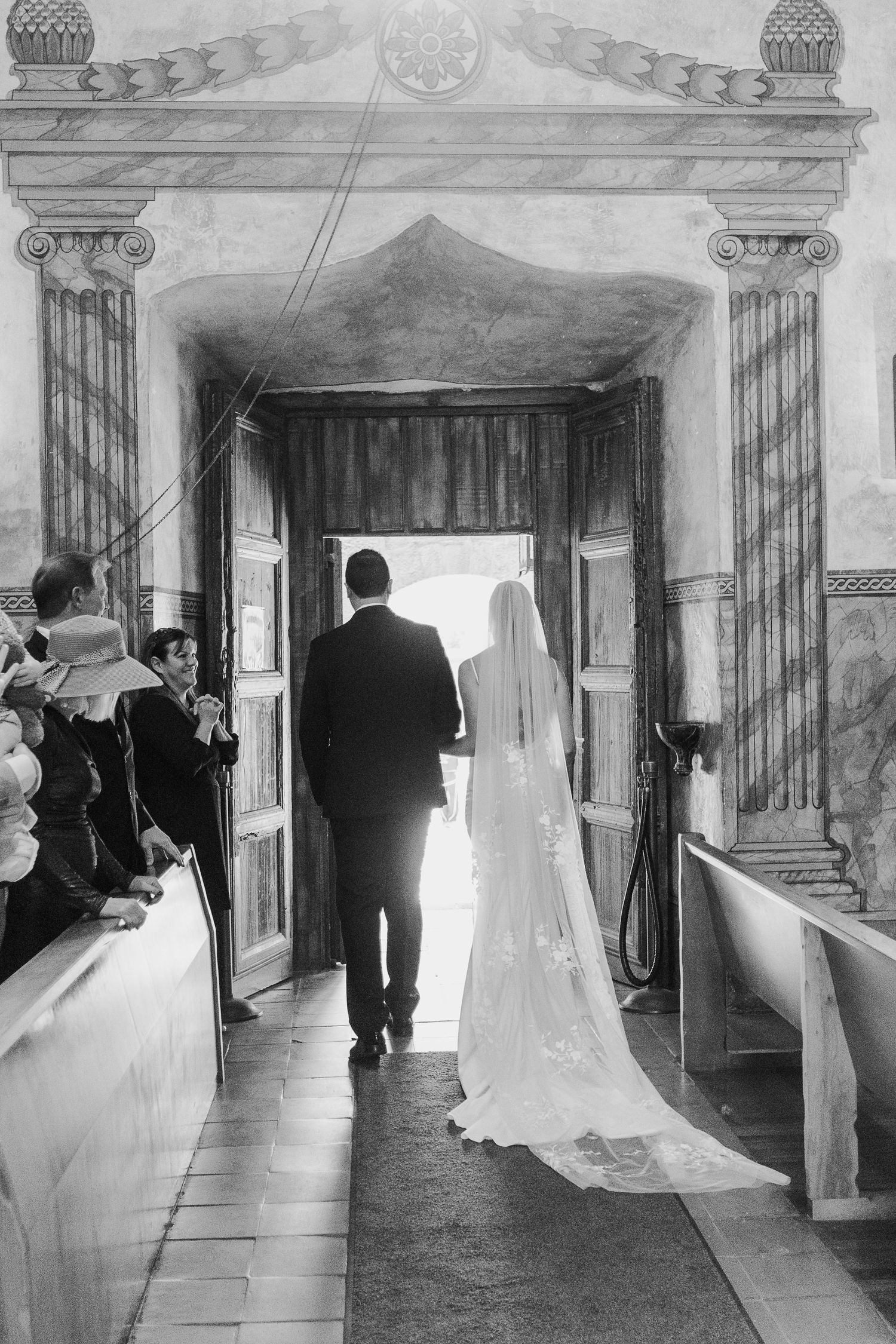 A wedding processional in a historic church with dramatic lighting and architectural details.