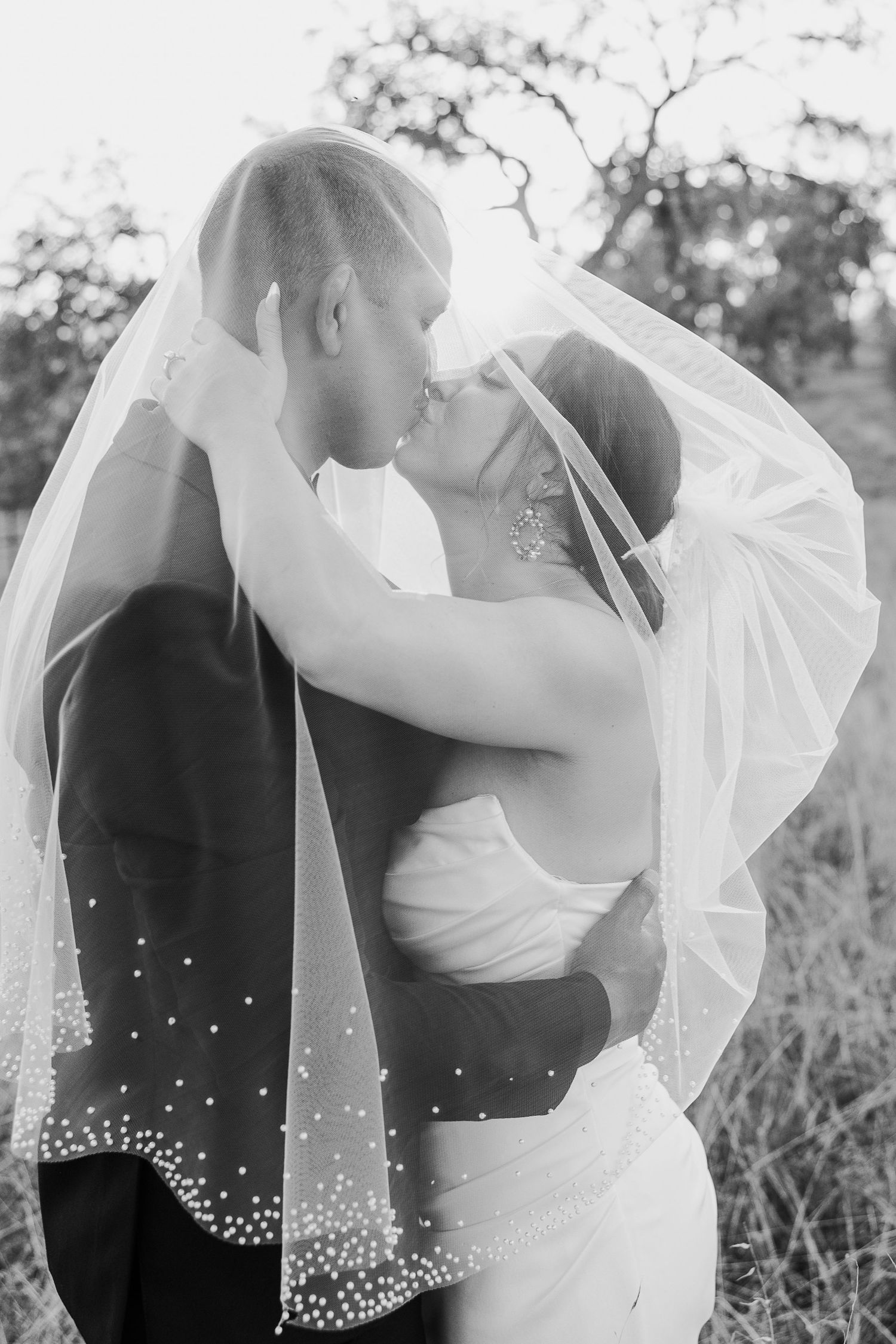 Black and white wedding portraits showing intimate moments with the bride's veil flowing in the breeze.