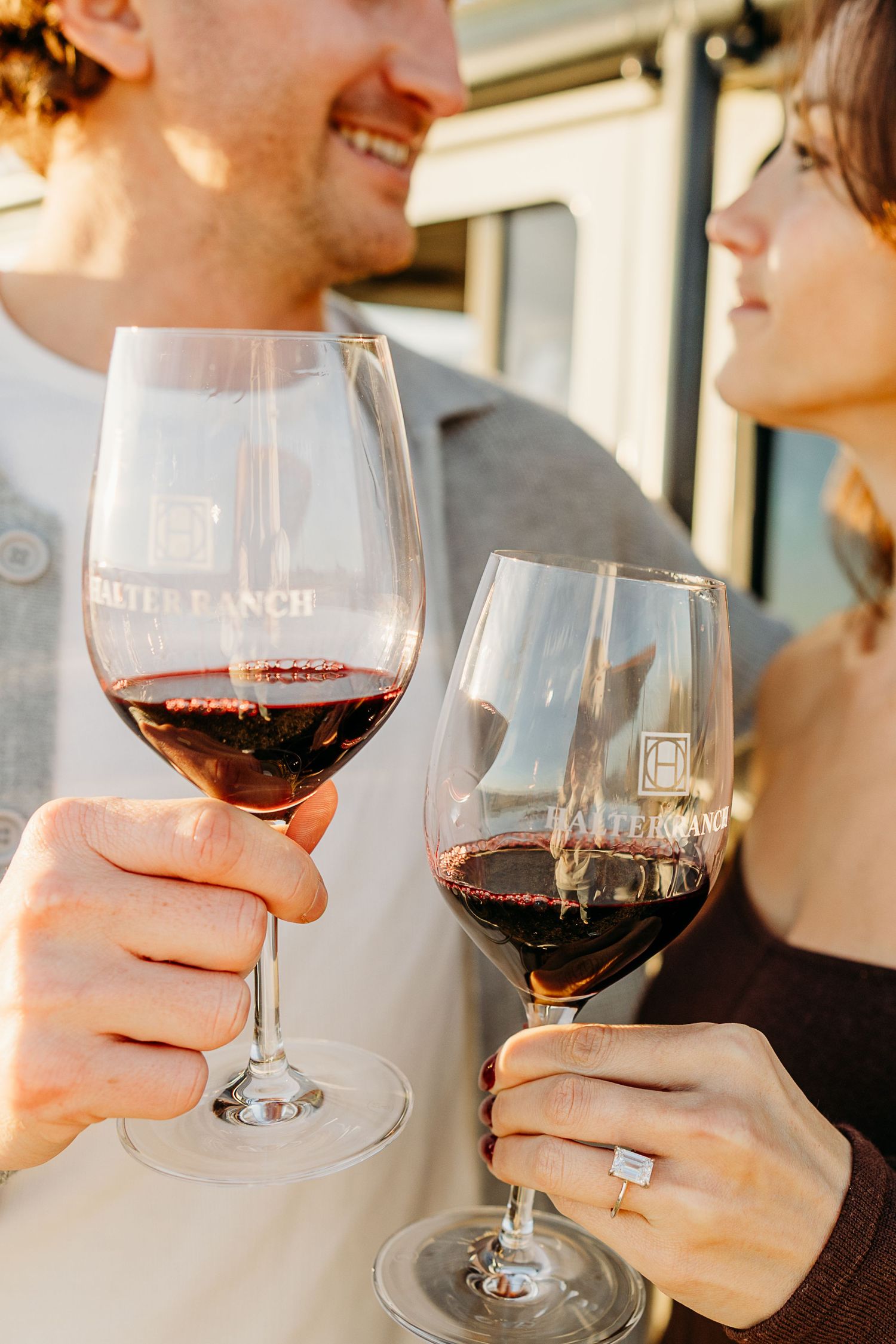 Close-up of wine glasses being held during romantic wine tasting experience.