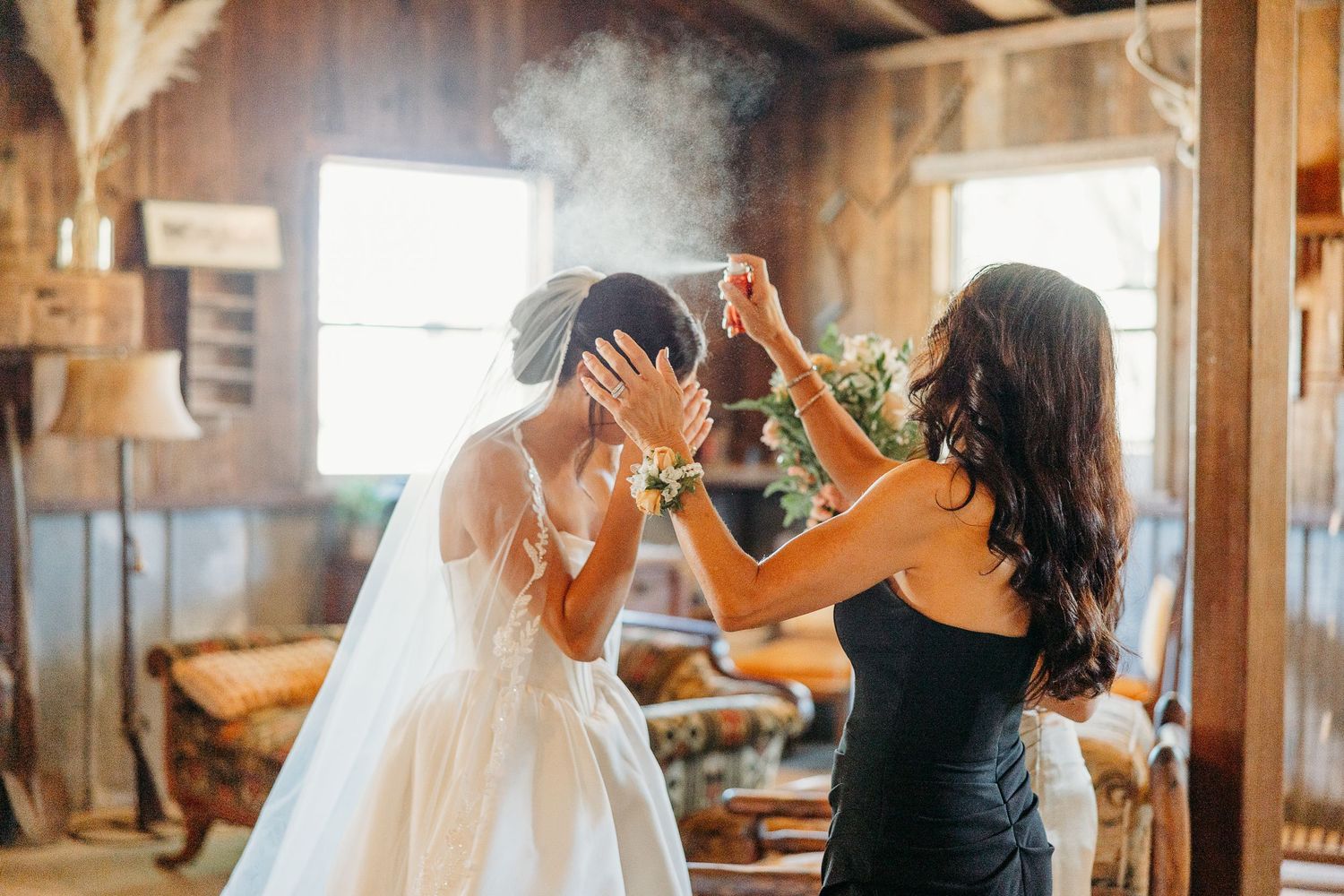 A couple dances together in a rustic wooden barn with warm lighting streaming through windows.