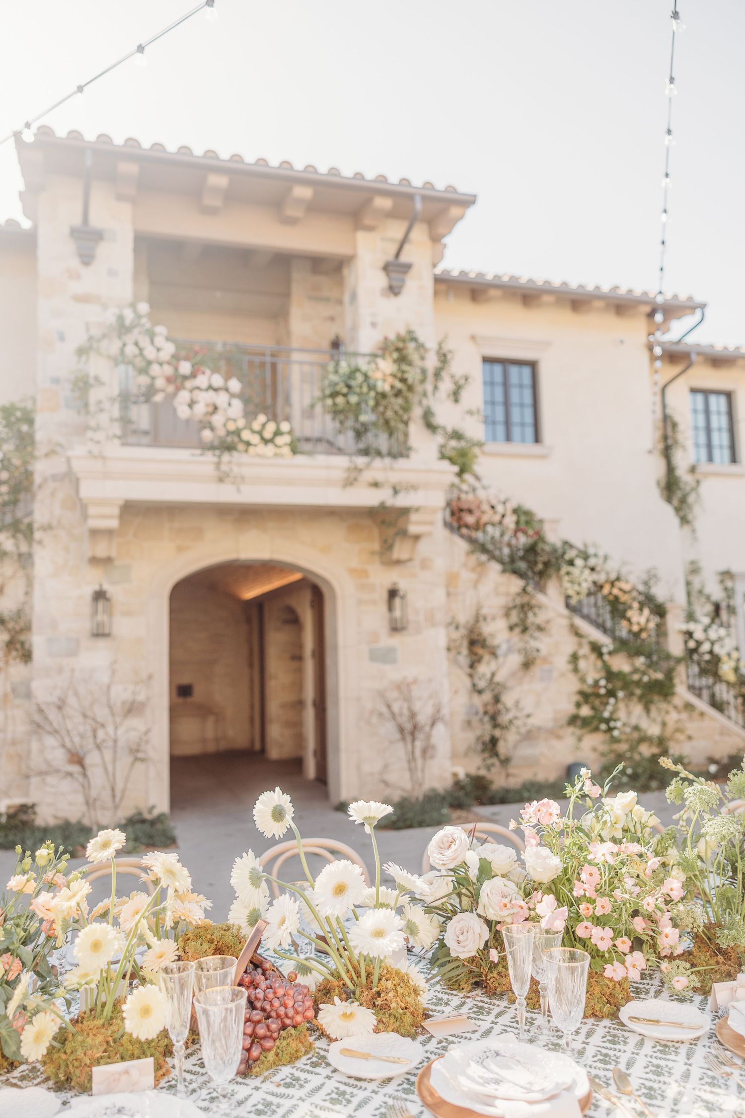 Mediterranean villa with outdoor wedding table setup and floral decorations.