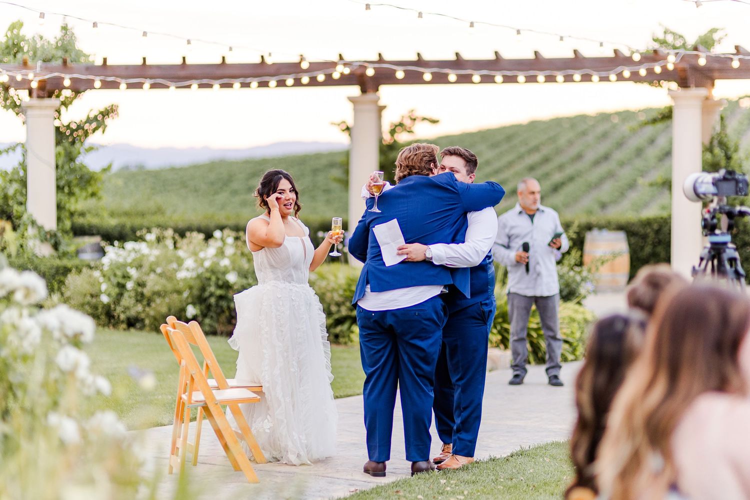 Wedding celebration on a garden path overlooking scenic vineyard hills.