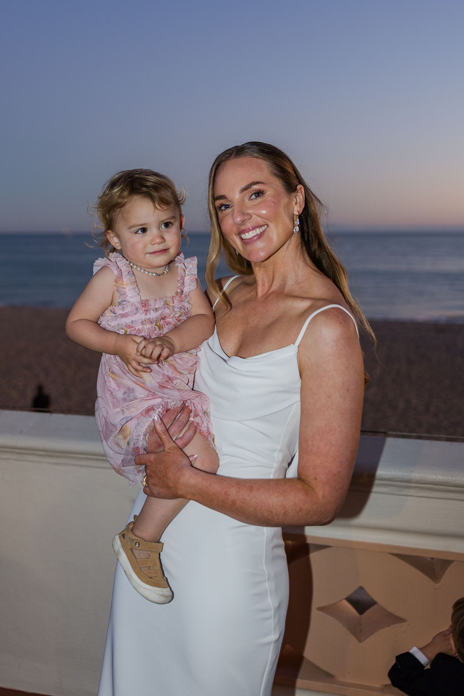 A tender moment captured at sunset during a beach wedding celebration.