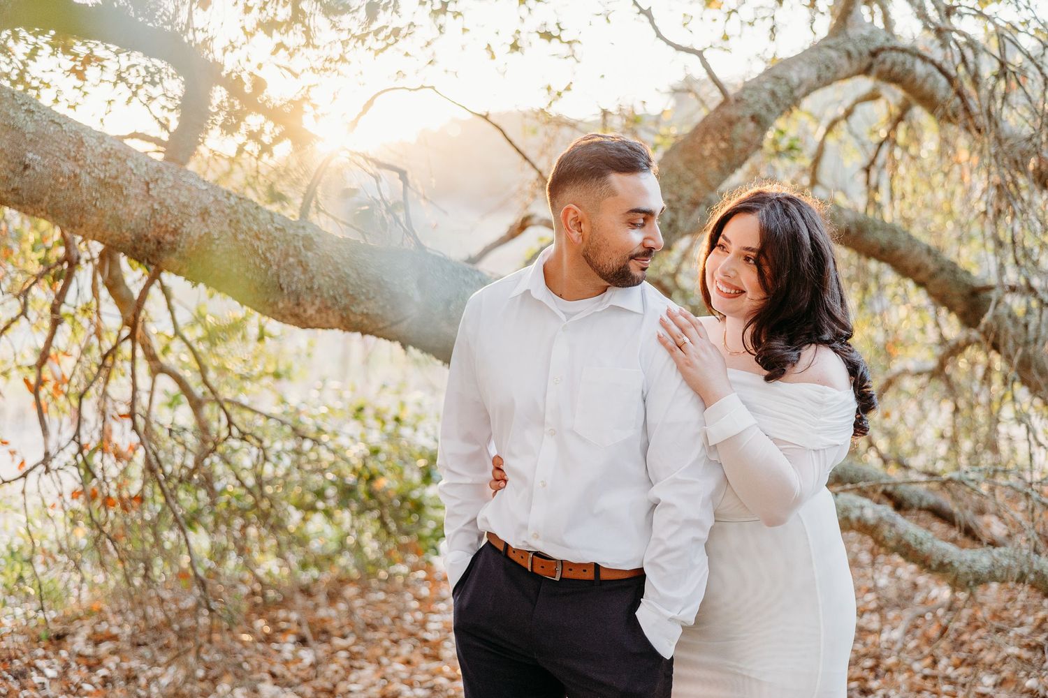 A romantic autumn engagement session among fall foliage with soft natural lighting.