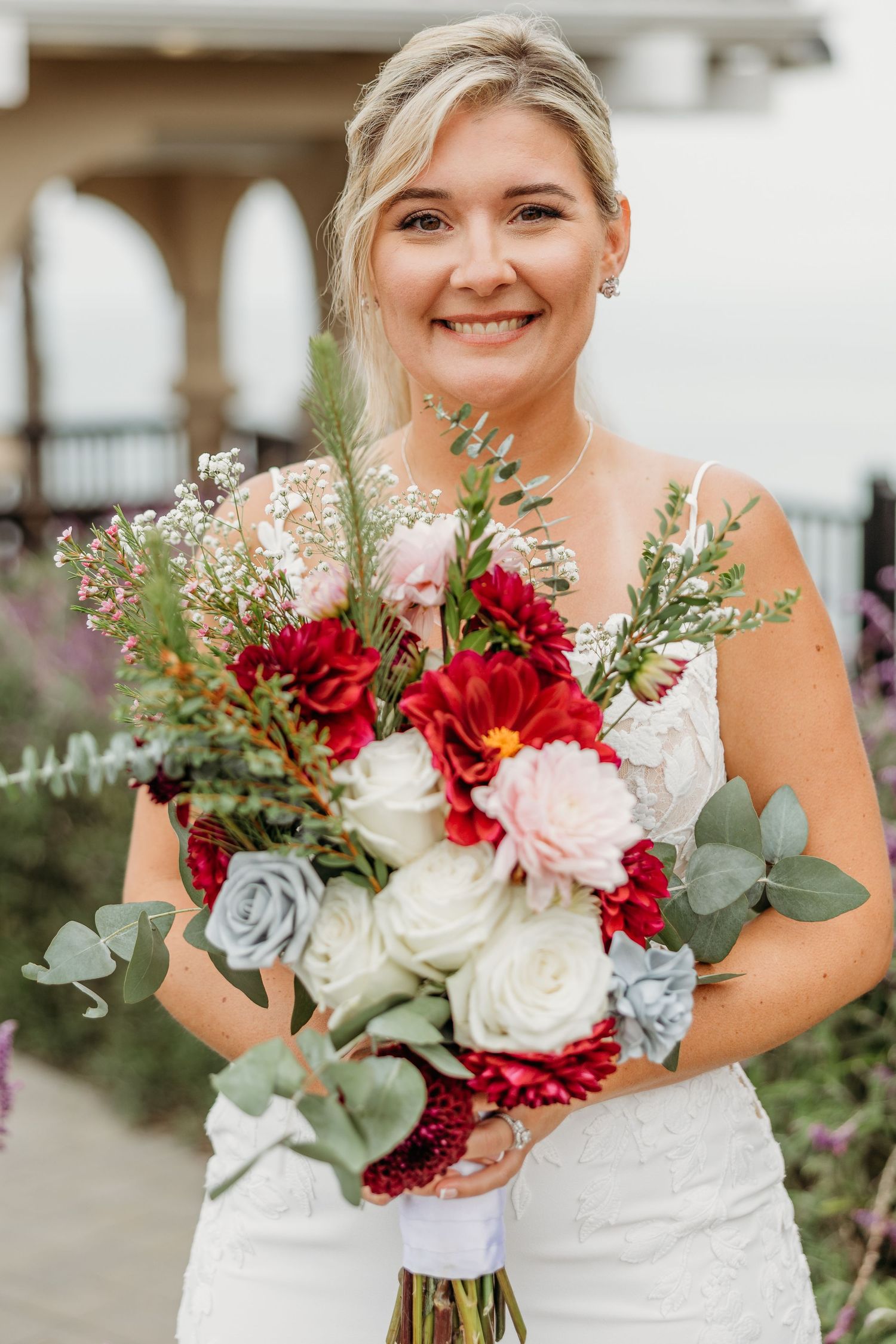 Beautiful bridal portrait with red, white and blue coastal-themed wedding bouquet.