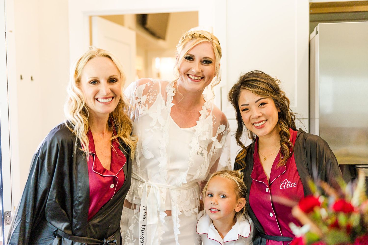 A group photo during wedding preparations in a bright indoor setting.