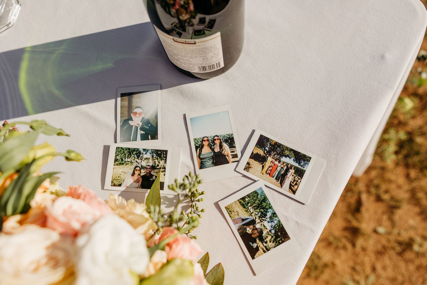 Wedding photo album pages with printed photographs and wine bottle.