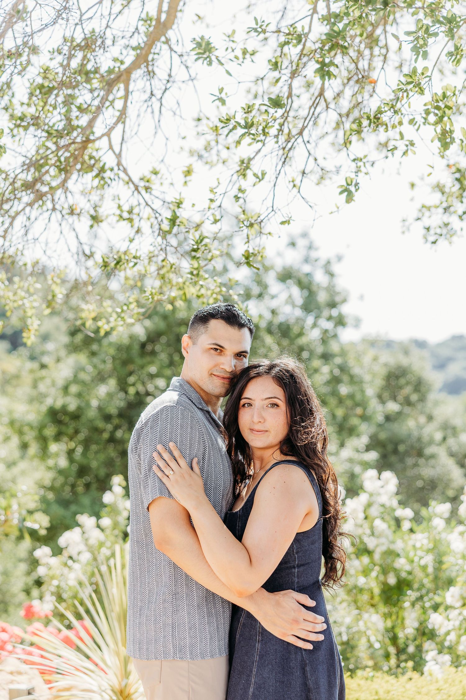 A tender moment between a couple posing together against a scenic natural background.