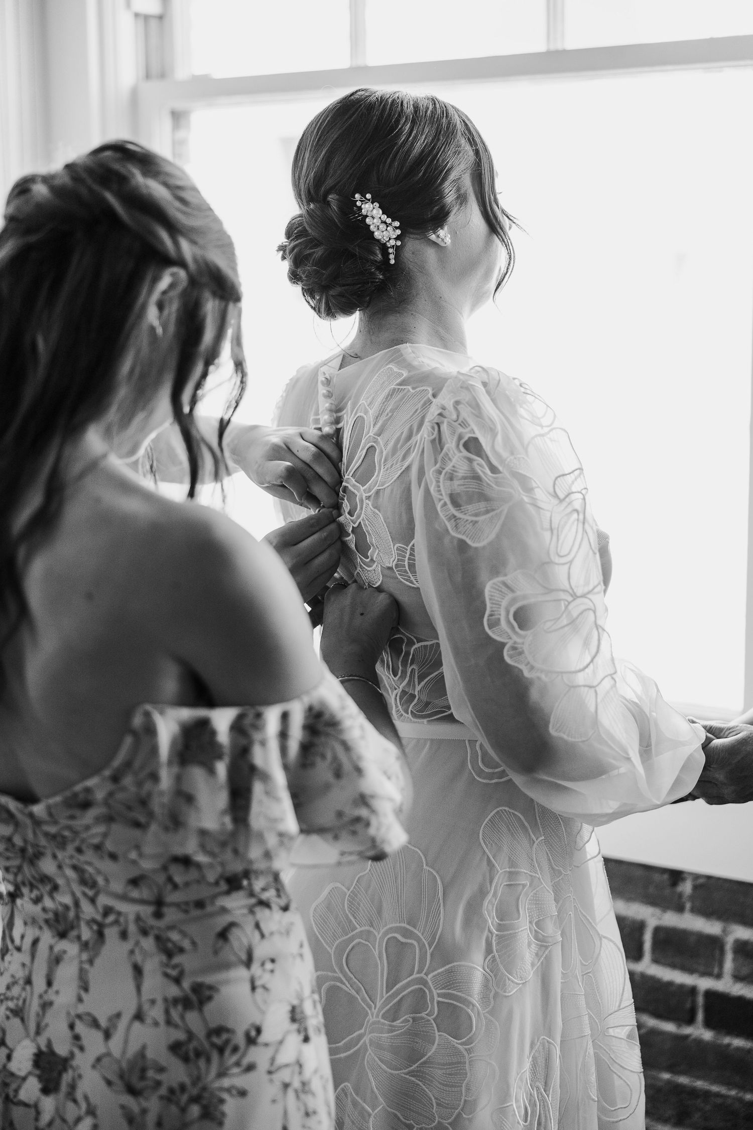 Black and white image showing elegant bridal hair styling with delicate hair accessory in a suite at Hotel Cerro San Luis Obispo.