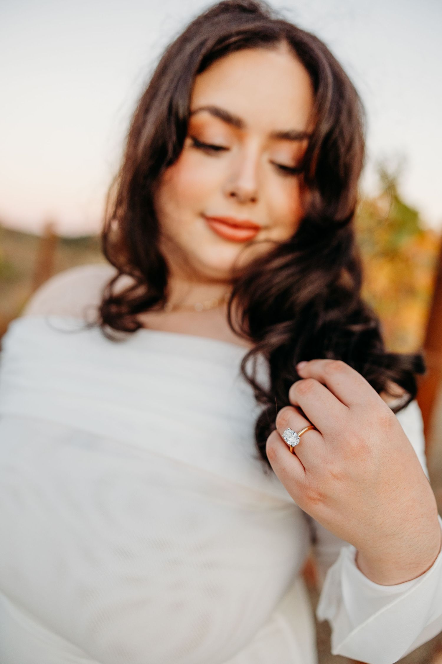 Close-up shots showing a sparkling engagement ring on a hand against a soft blurred background.