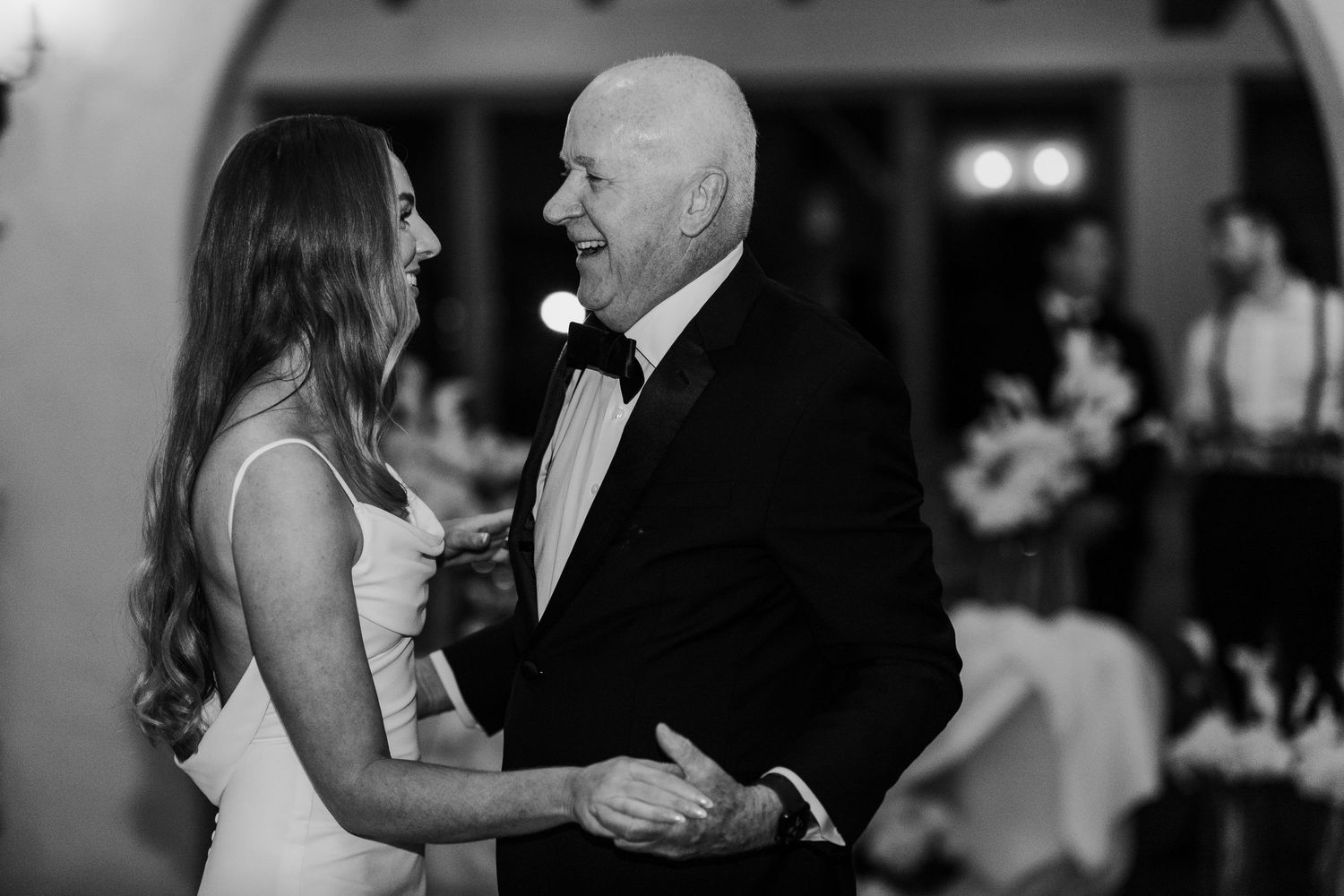 A black and white candid moment during an elegant wedding reception.