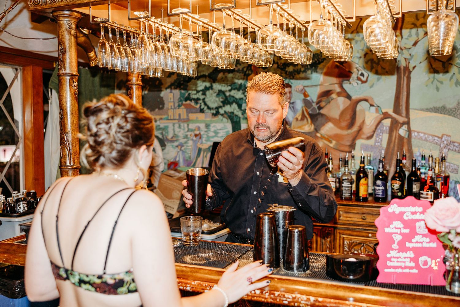 Wedding reception venue with hanging lights and rustic wooden beams creating a warm atmosphere.