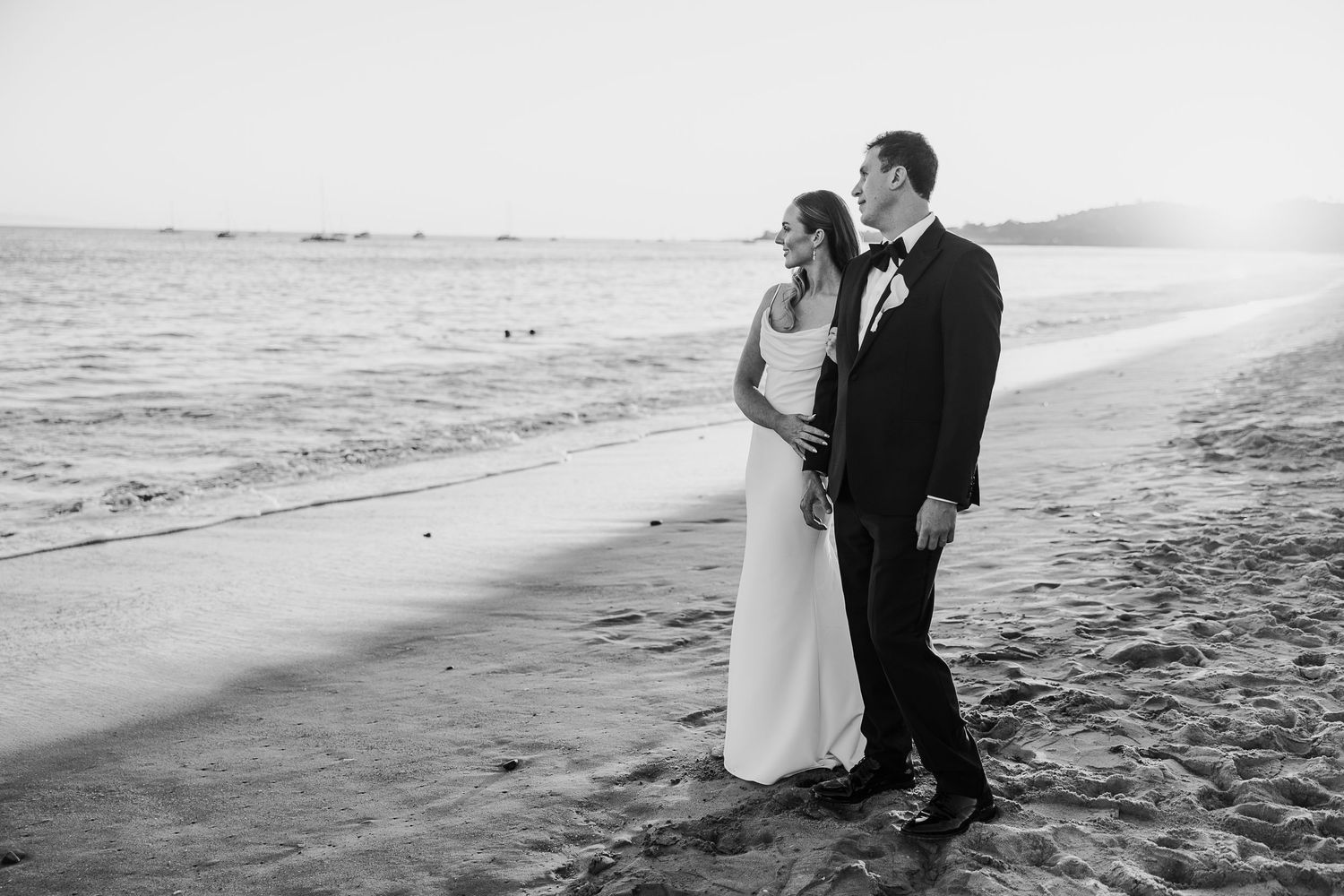 Black and white photos capture a romantic beach wedding photoshoot at sunset.