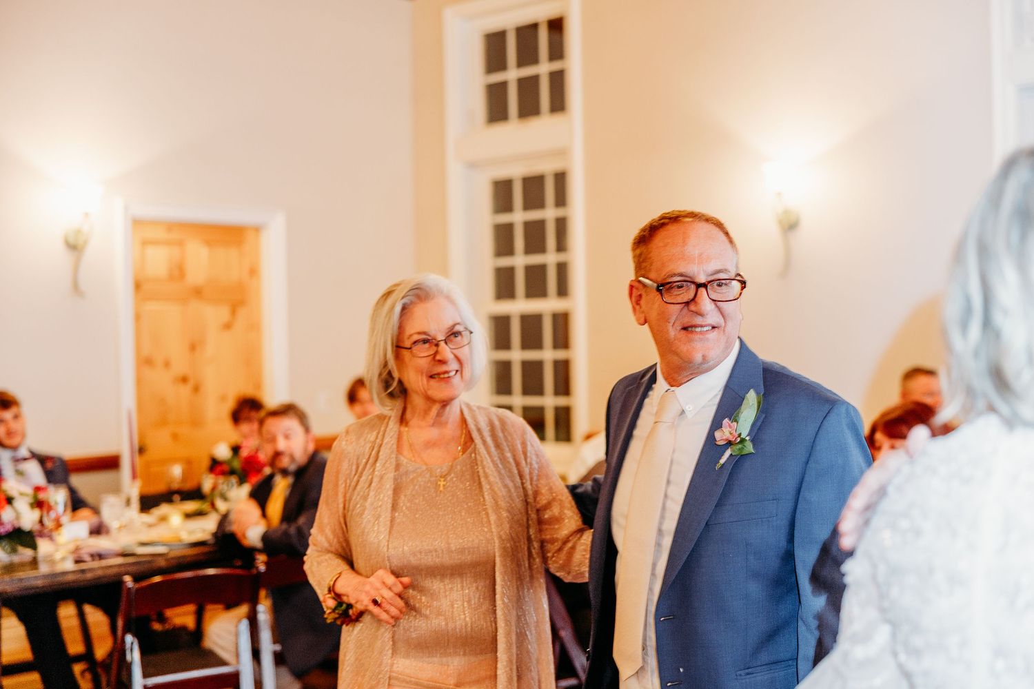 Indoor wedding reception venue with warm lighting and elegant table settings.