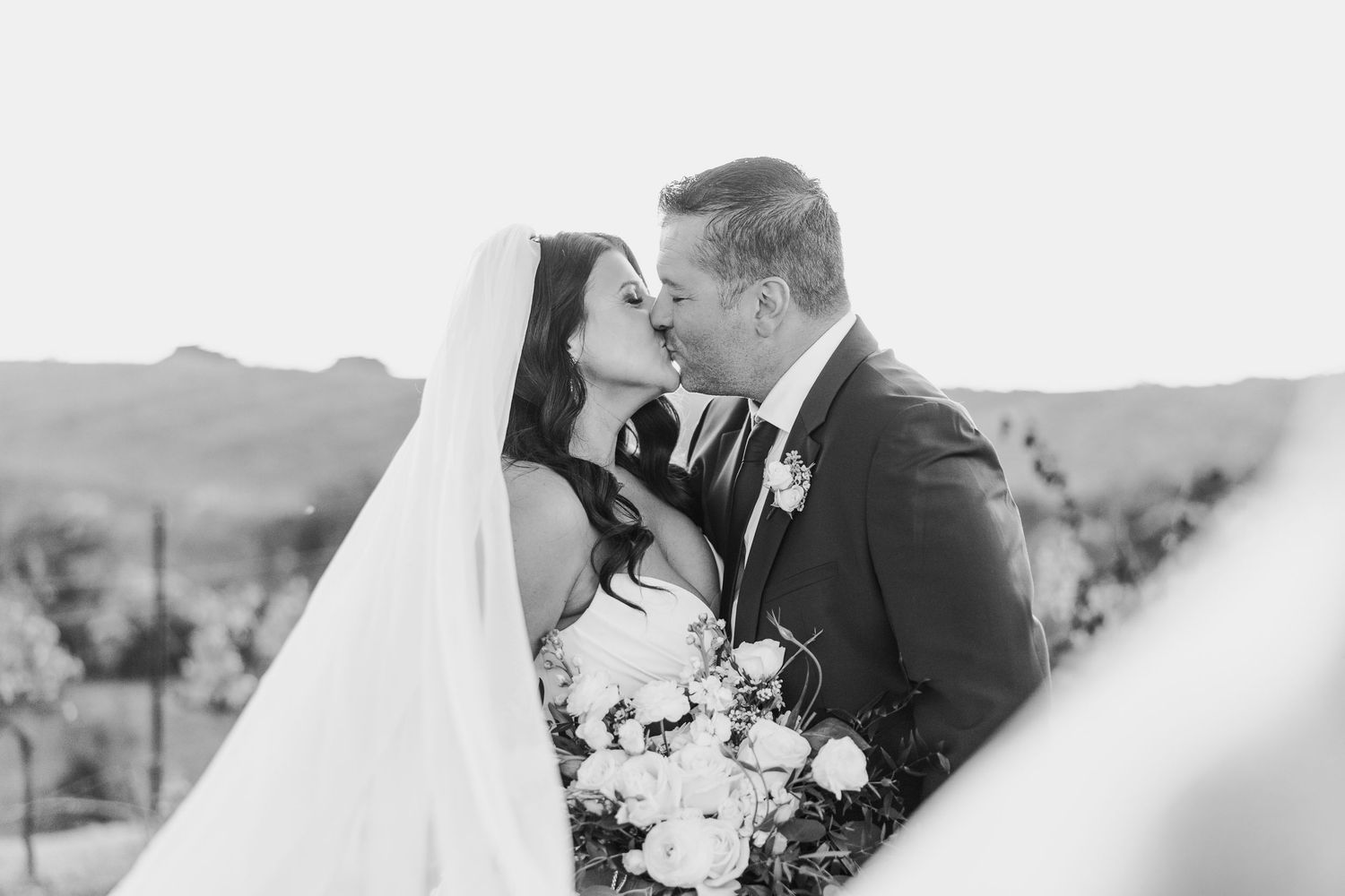 Romantic black and white wedding portraits captured in a natural outdoor setting.