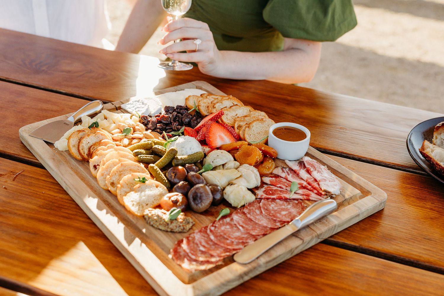 Gourmet meat and cheese platter displayed on rustic wooden table.
