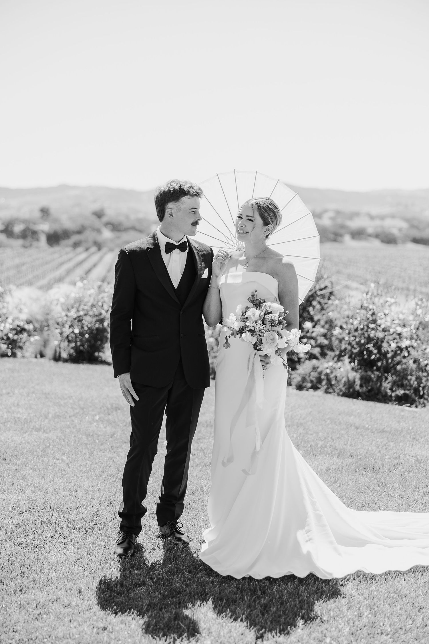 Black and white panoramic series of a couple in formal wedding attire posing in a scenic outdoor garden setting.