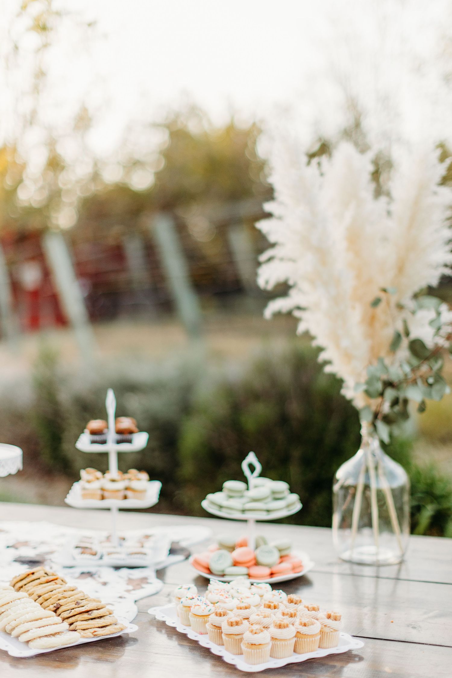 An elegant dessert table with white floral decorations displays various treats and sweets.
