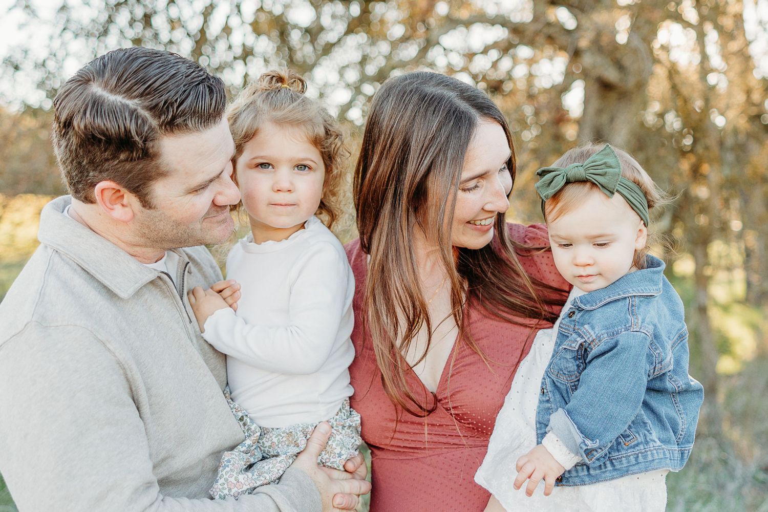 Family portrait session in autumn woodland setting with golden light.