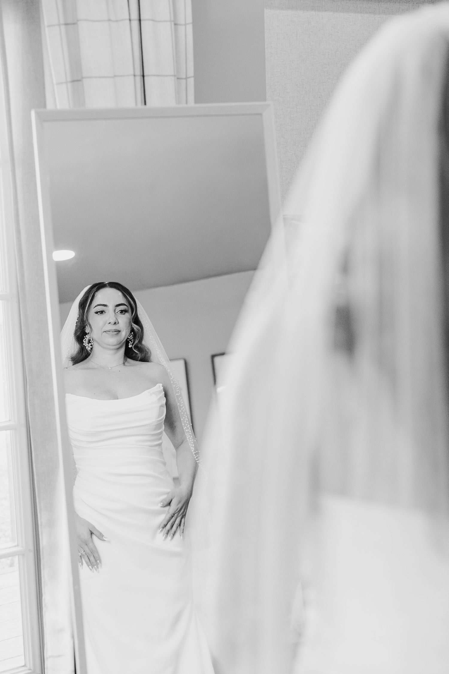 Elegant black and white bridal portraits showing preparation moments in a light-filled room.