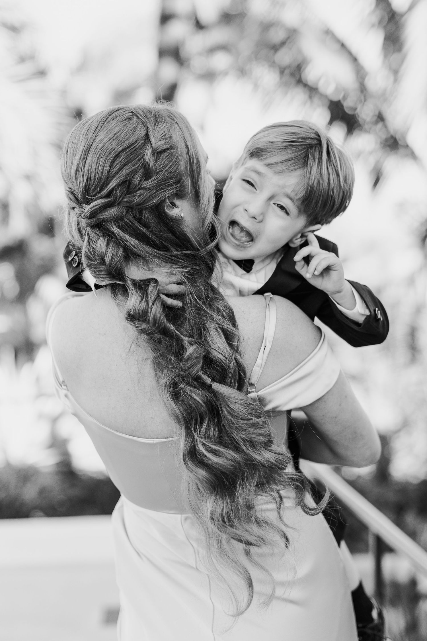 A tender black and white portrait capturing an intimate moment between parent and child.