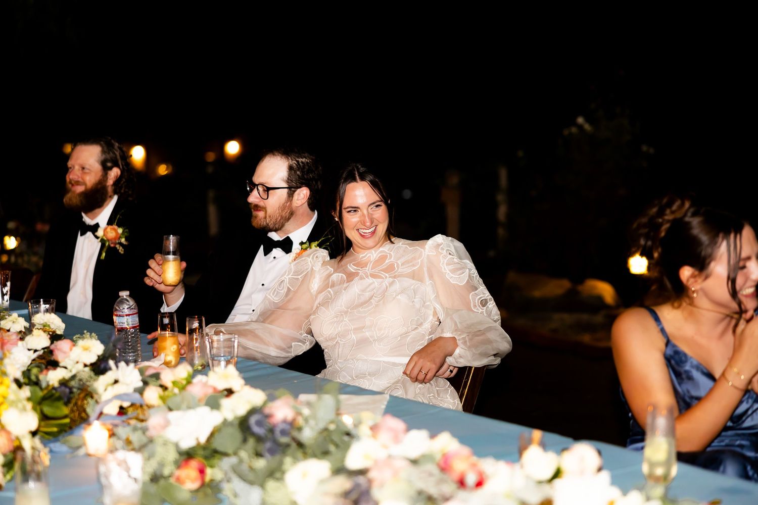 Wedding reception dinner scene with elegant floral centerpieces and ambient lighting at Holland Ranch SLO.