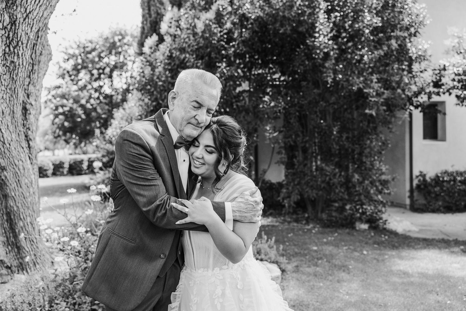 A black and white portrait of a couple sharing an intimate wedding moment.