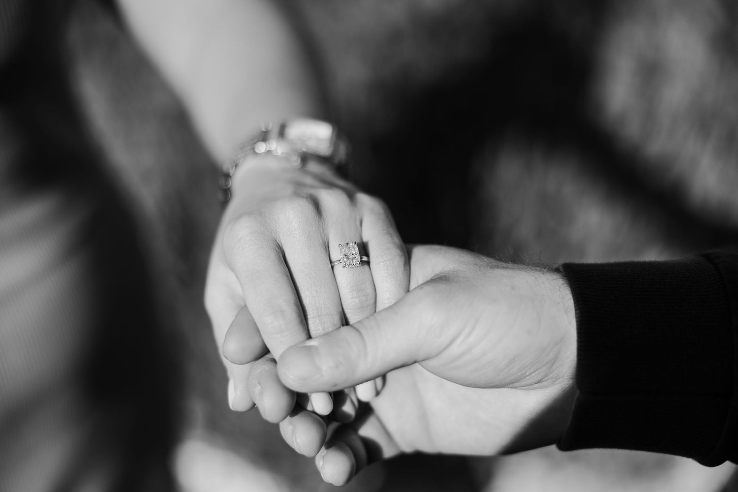 Close-up detail shots of people holding hands in black and white photography.