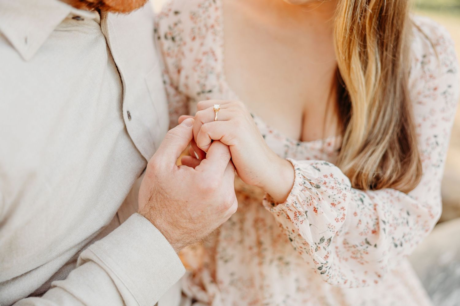 A close-up shot of two hands clasped together, with one wearing a lace sleeve dress.