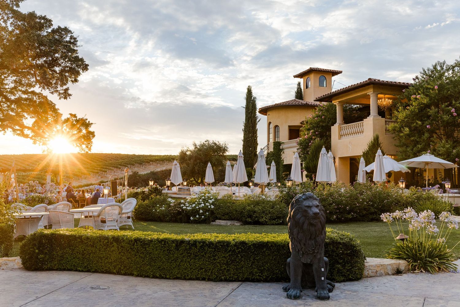 Elegant outdoor wedding reception setup at a Tuscan-style venue during golden hour.