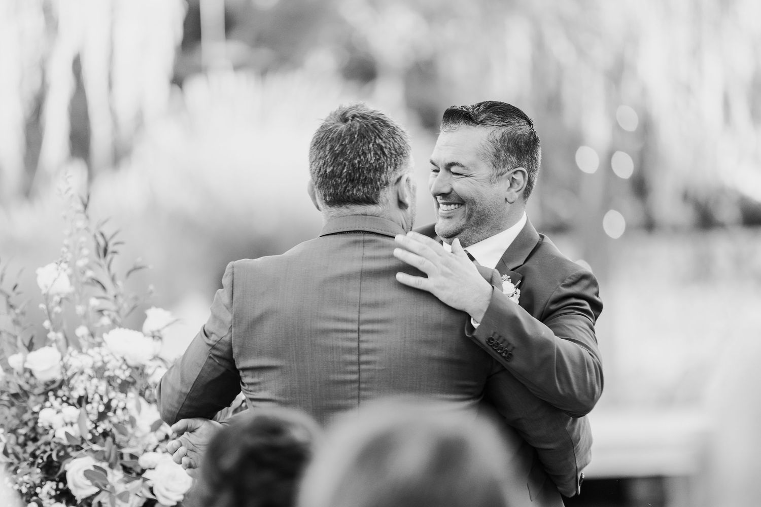 Black and white photo capturing emotional reactions of wedding ceremony attendees.
