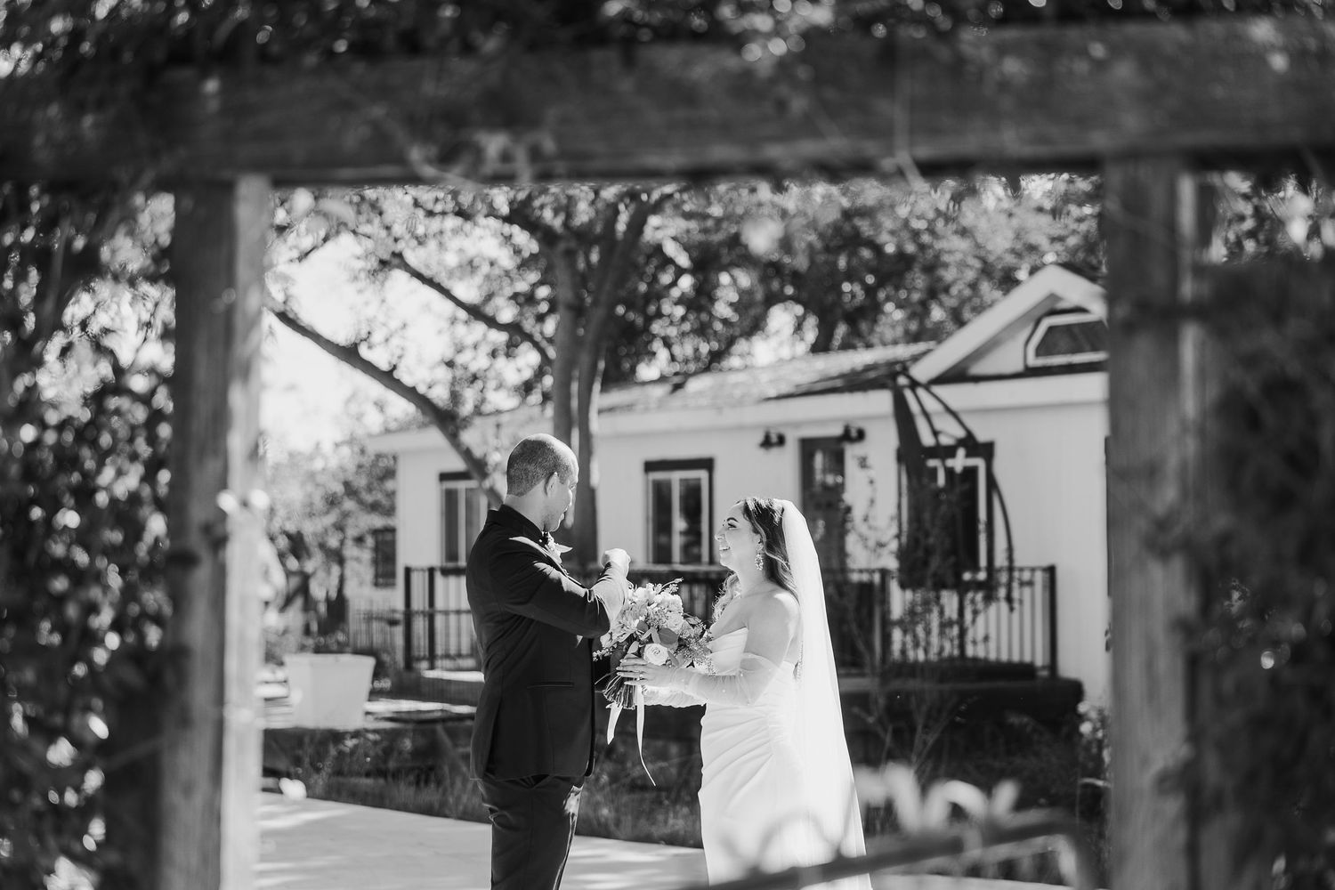 Outdoor wedding ceremony setup with white chairs and floral arrangements.