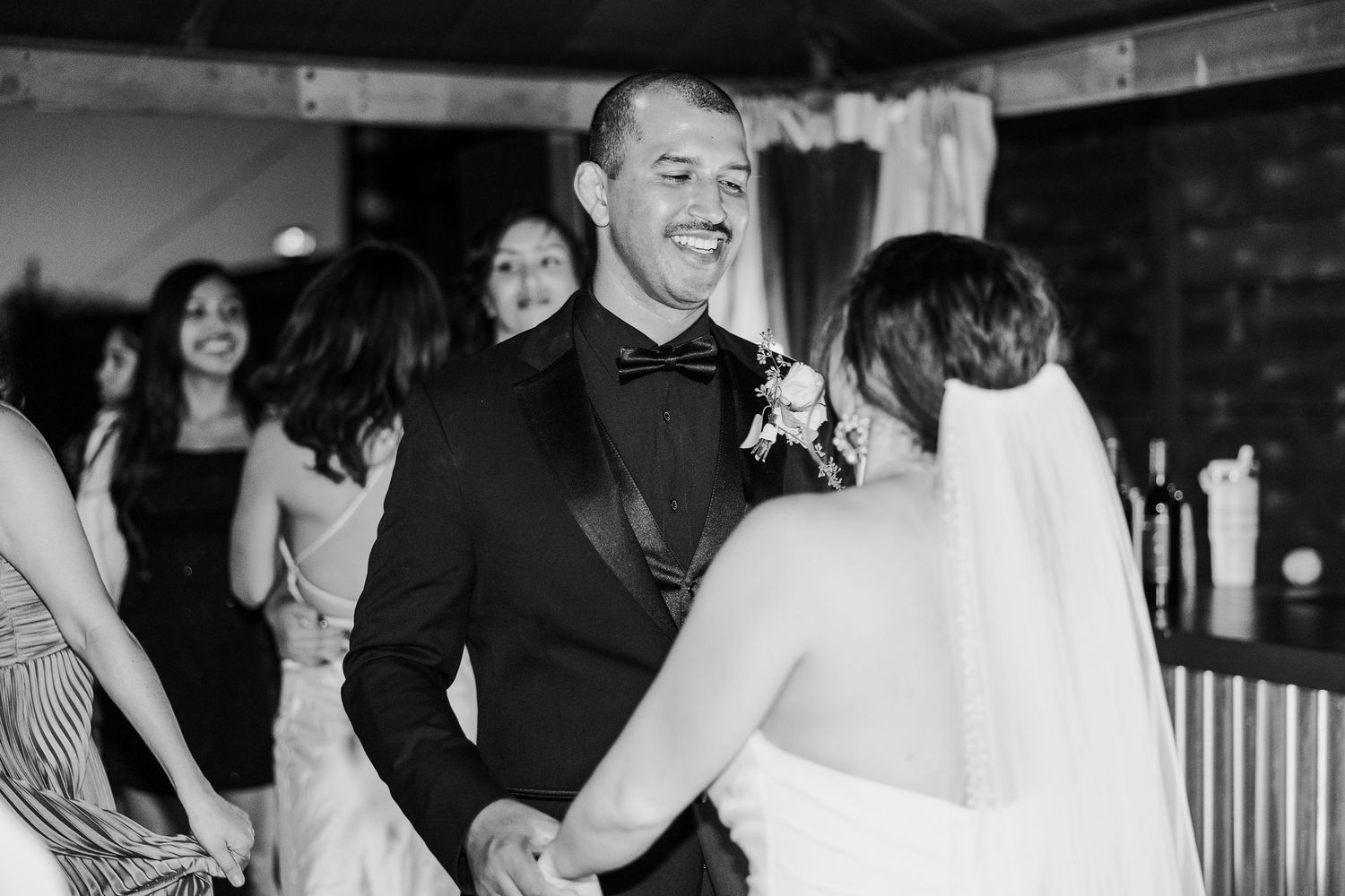 Wedding reception candid moments captured in black and white photography.