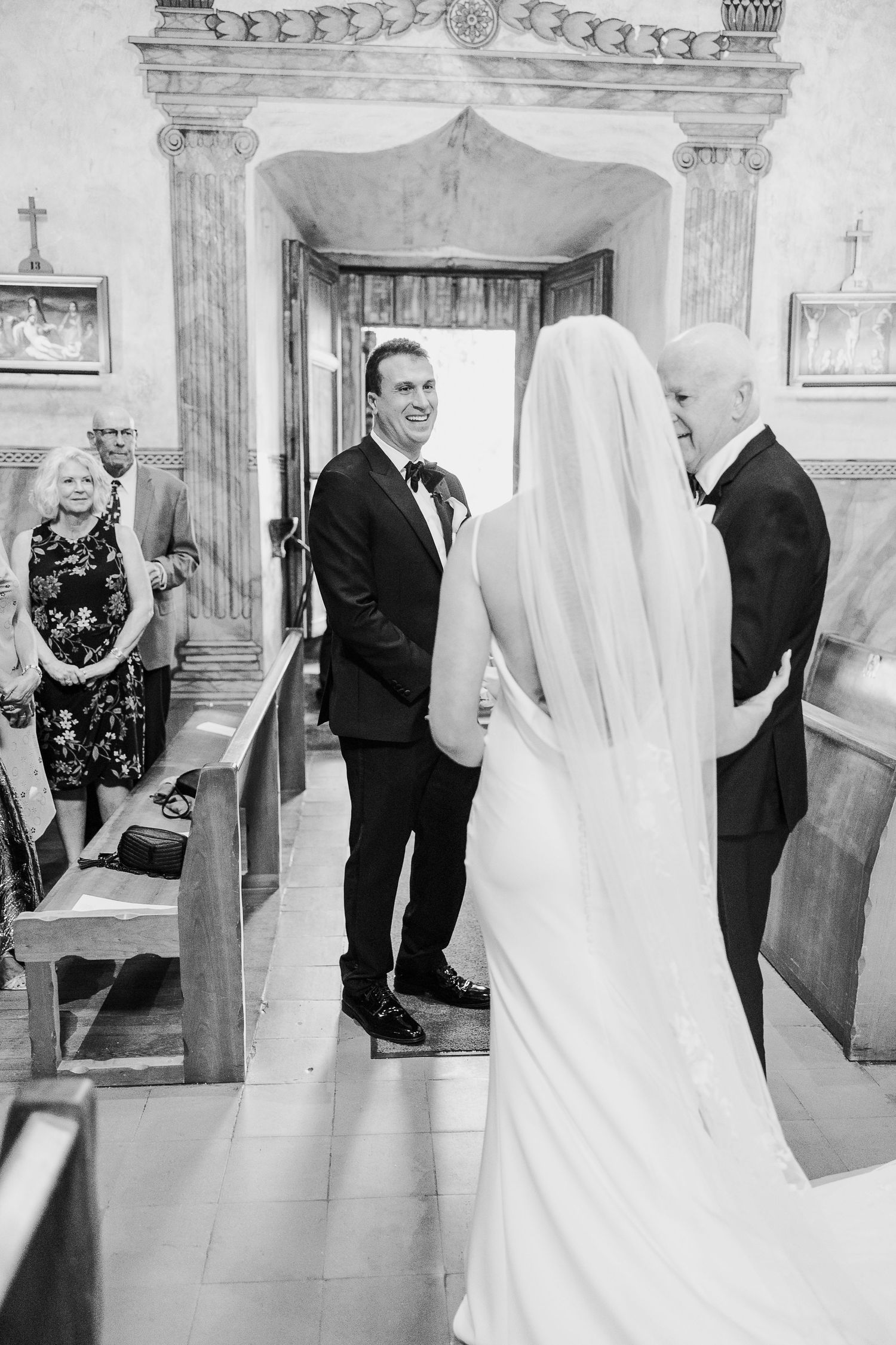 A wedding ceremony in a traditional church with ornate architectural details and decorative columns.