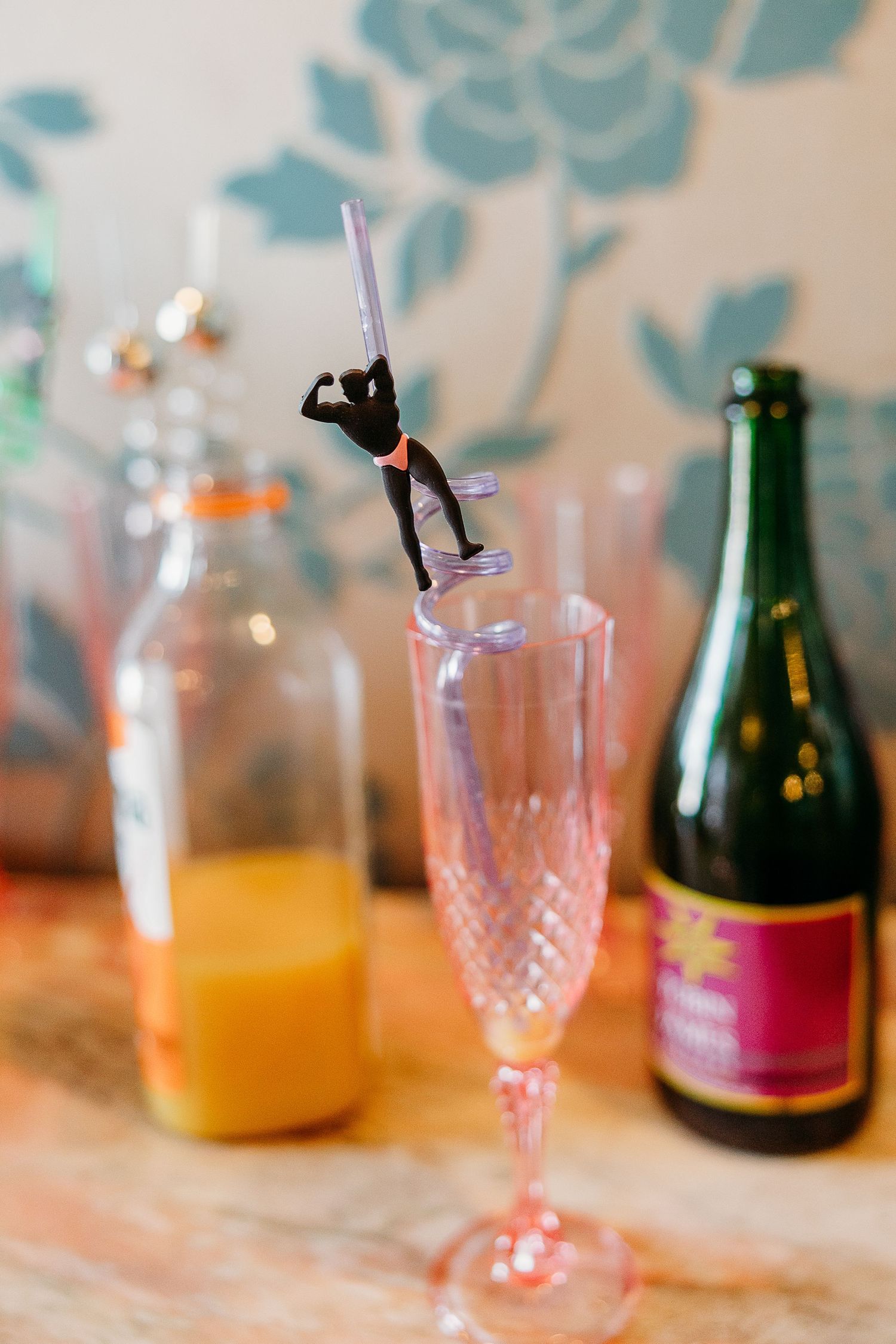 Crystal champagne glasses and bottles arranged on a table with soft lighting and floral decorations.
