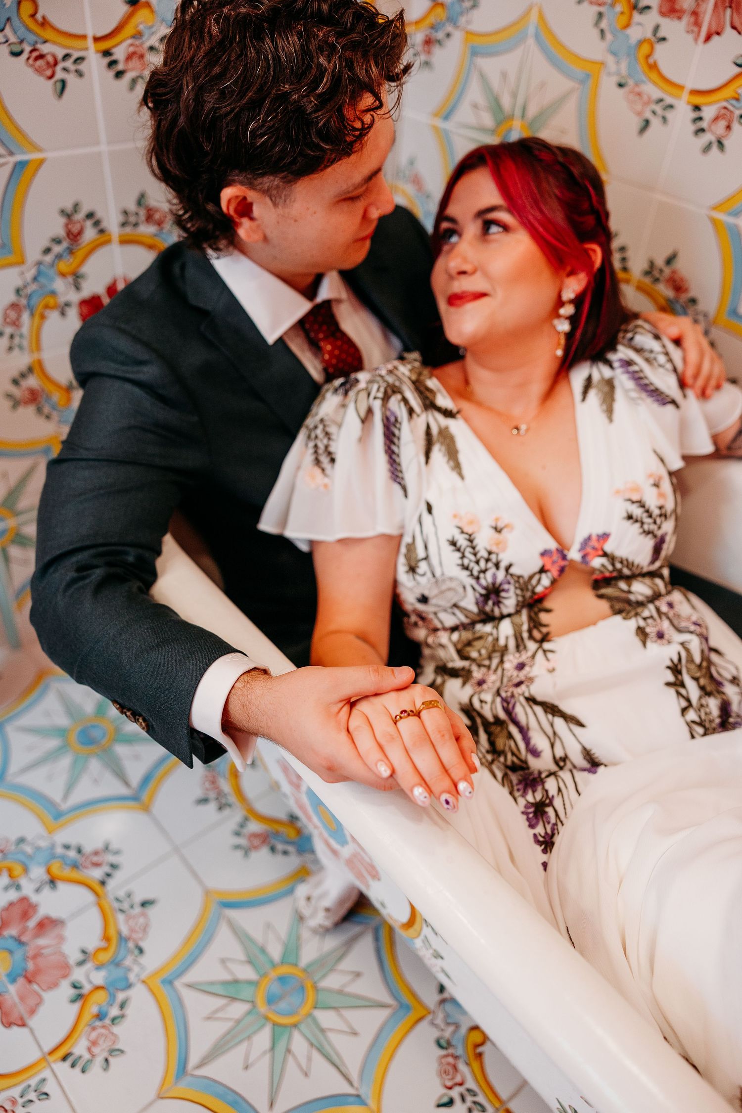 Couple shares romantic moment on ornate tiled floor during wedding celebration.