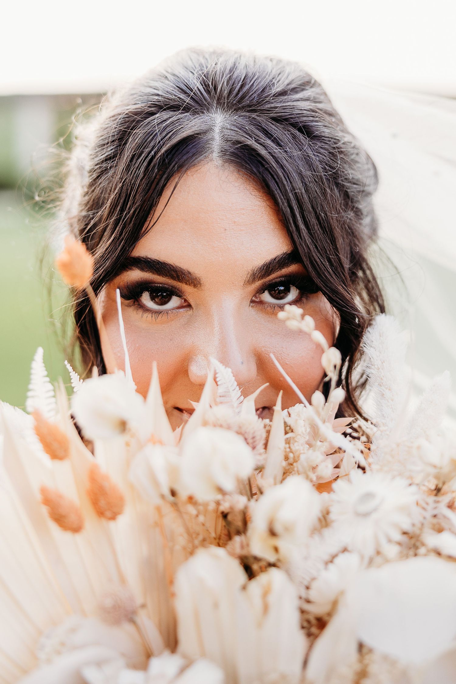 Close-up portrait with dried flower bouquet and bridal makeup.
