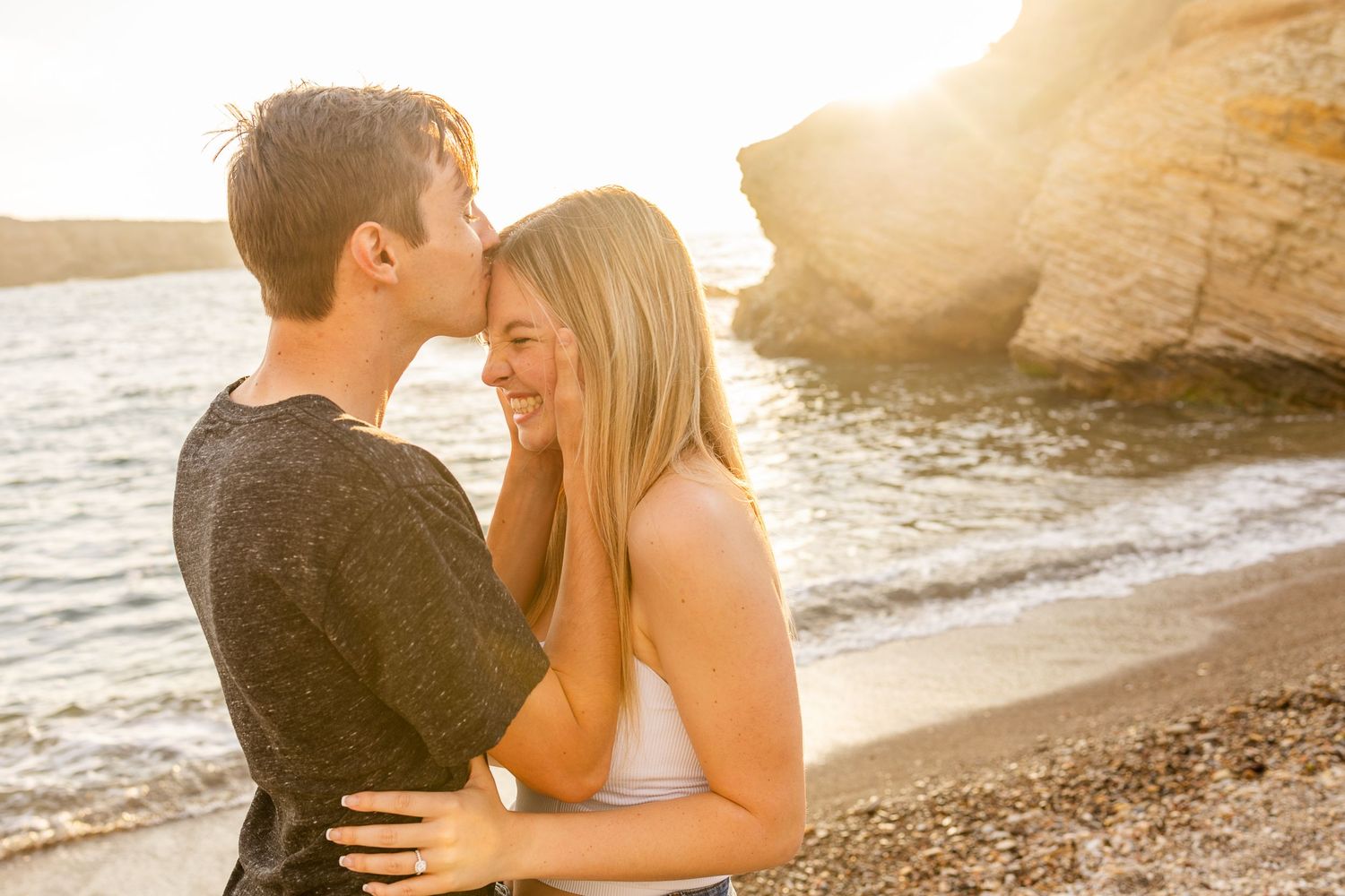 A romantic sunset beach scene with a couple in a close embrace.