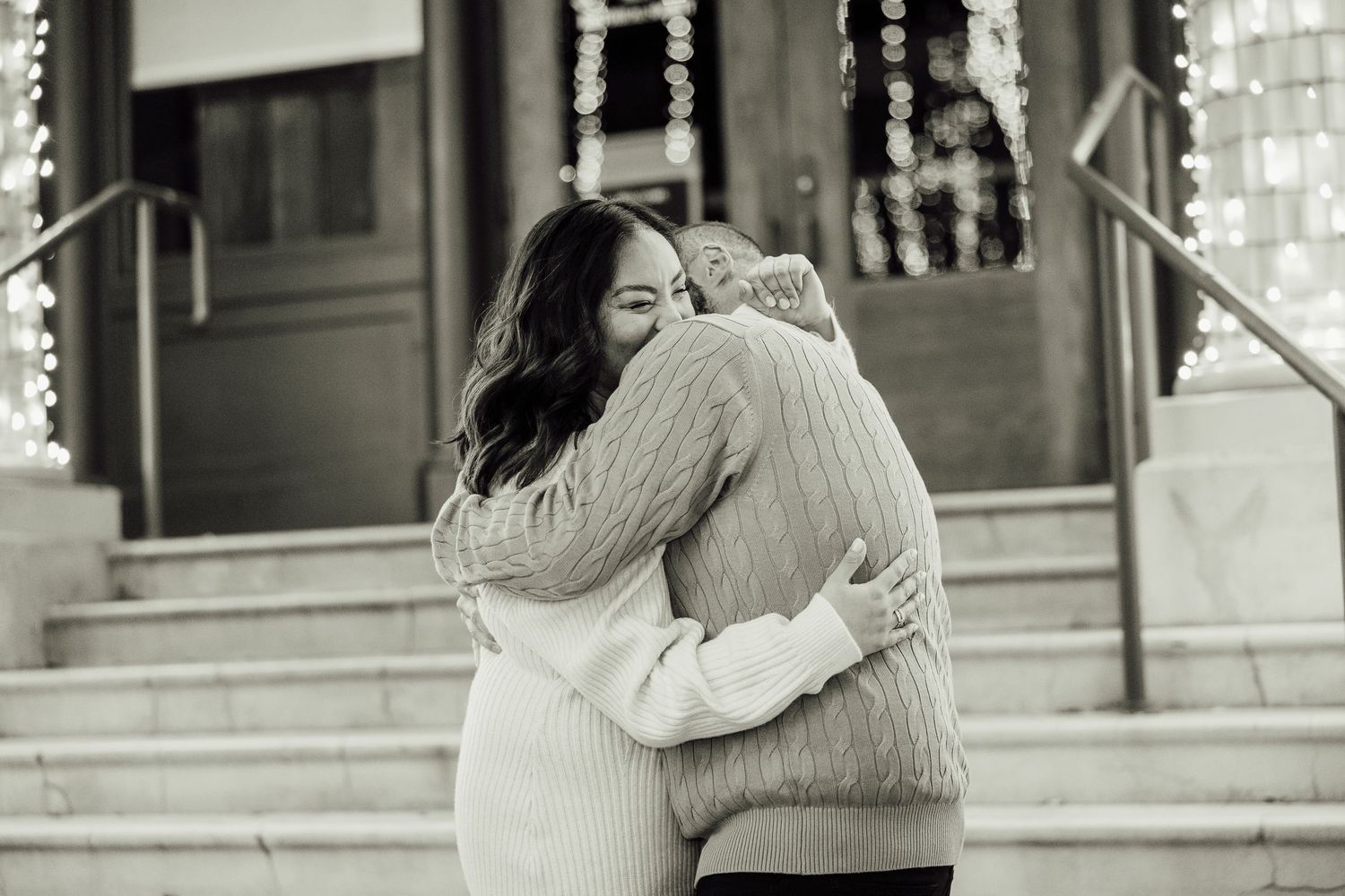 Two people embrace in a romantic moment captured in black and white photography.