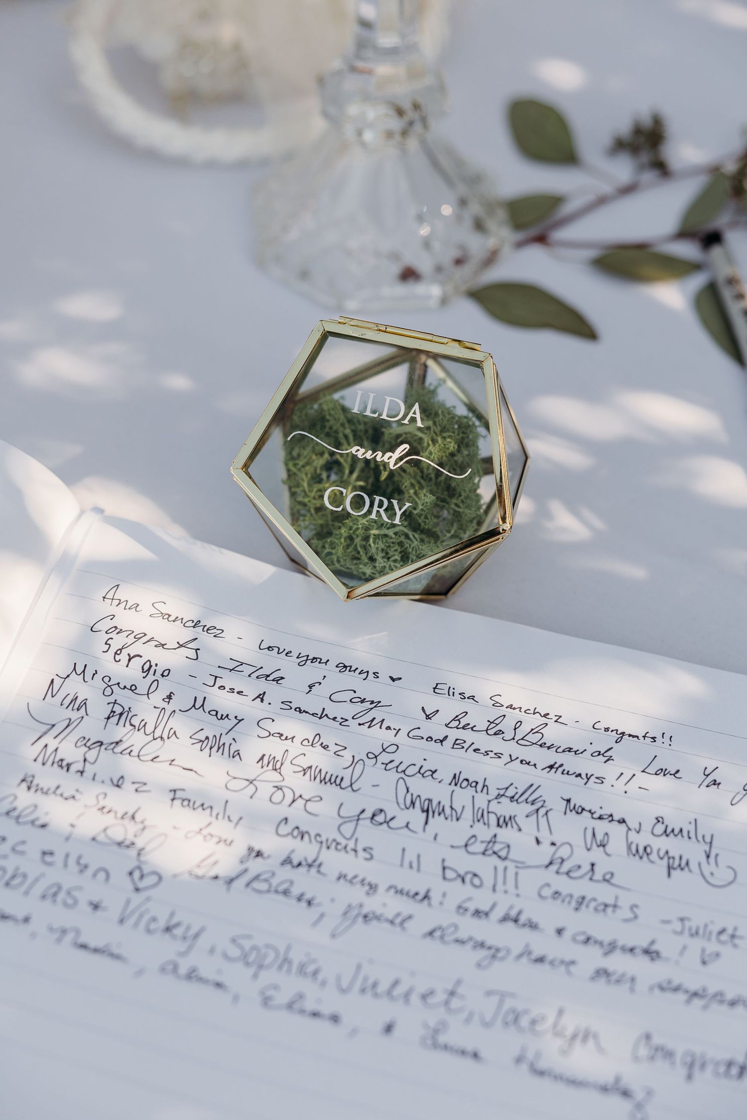 Wedding reception table details with handwritten notes and geometric place card holders.
