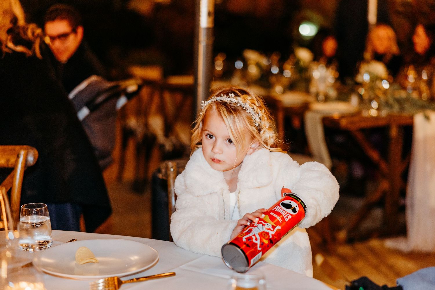 Children in formal attire enjoy themselves at an evening wedding reception.