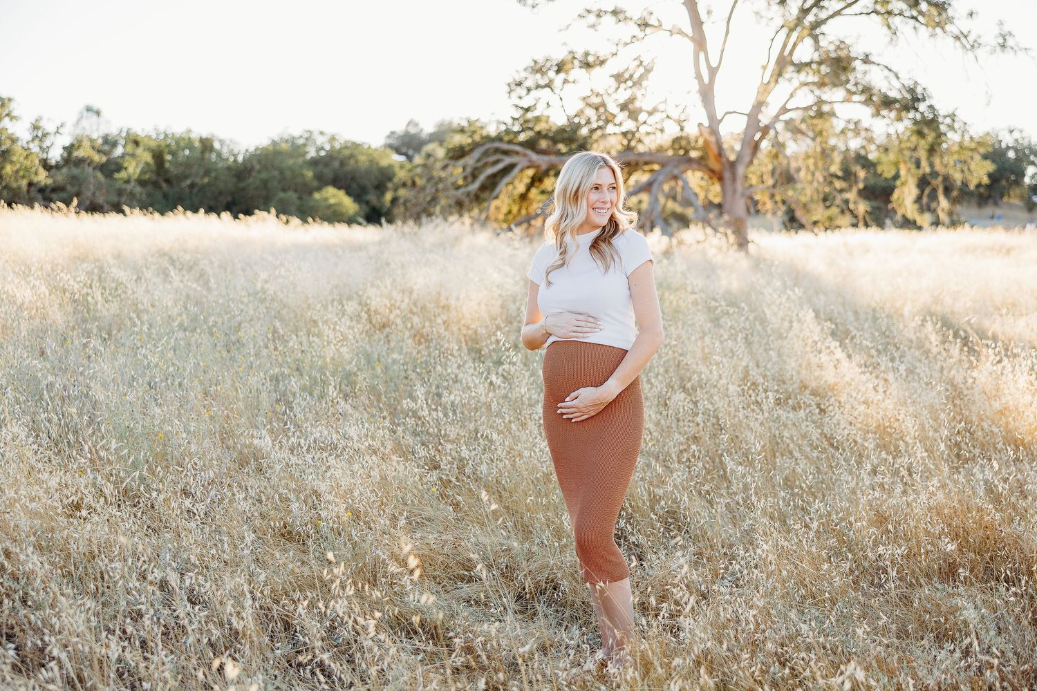 Professional lifestyle photoshoot in a sun-drenched field of tall grass.