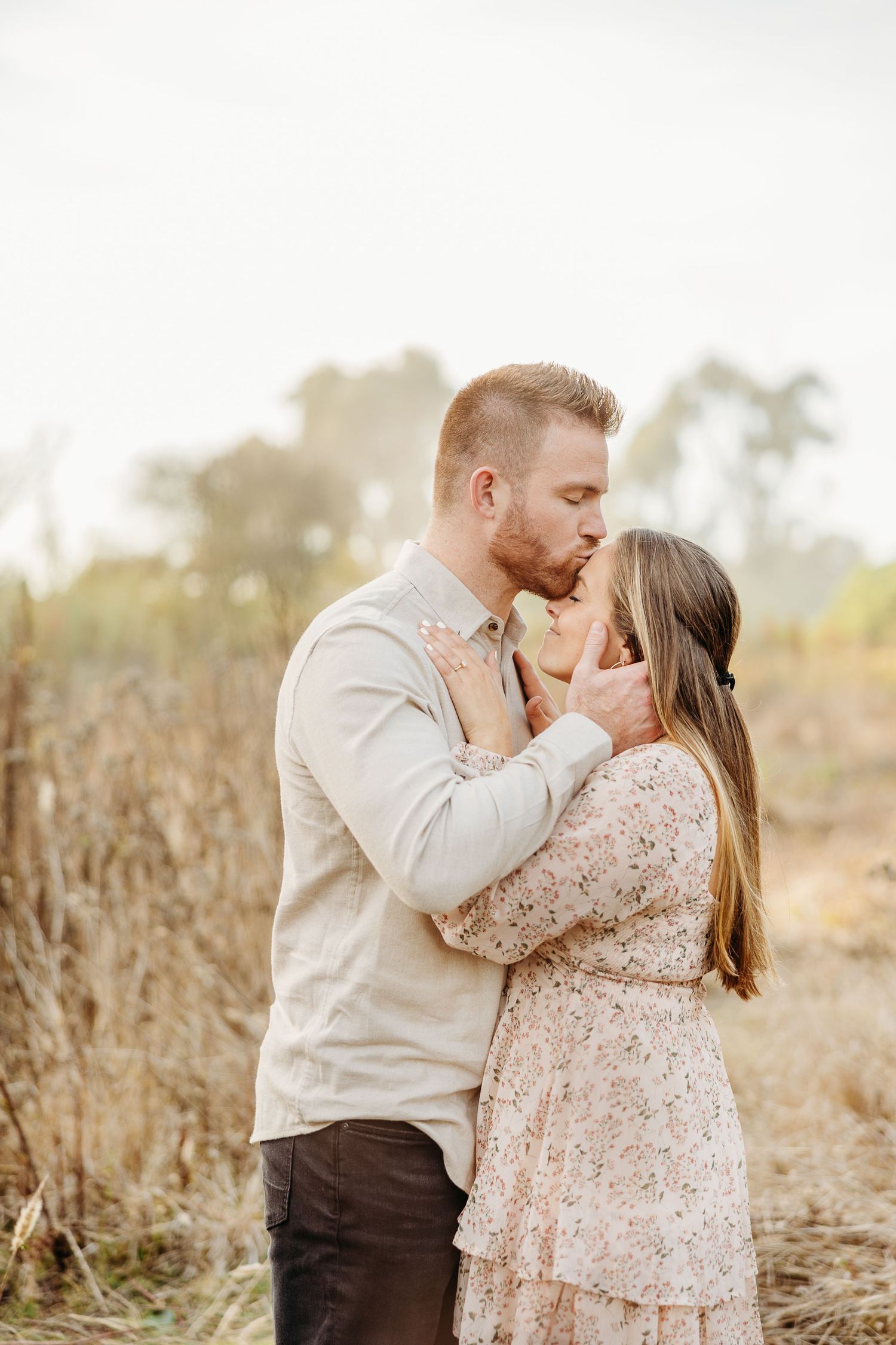 Intimate portrait of couple sharing tender moment in natural setting.