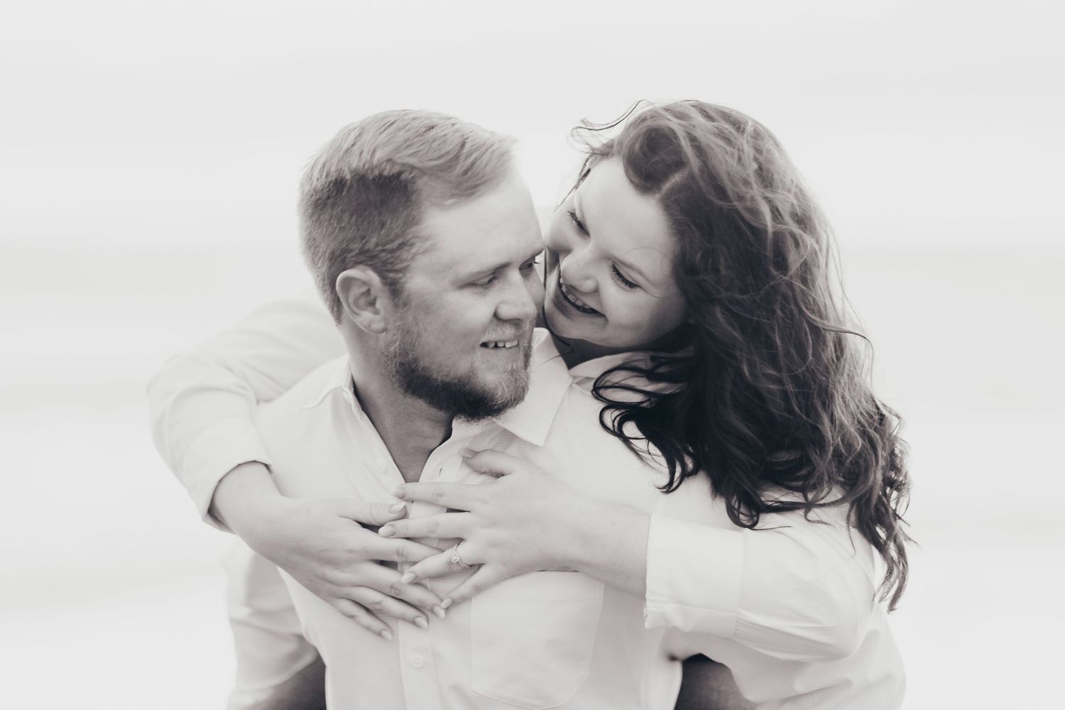 Intimate black and white portrait of a couple sharing a tender moment outdoors.