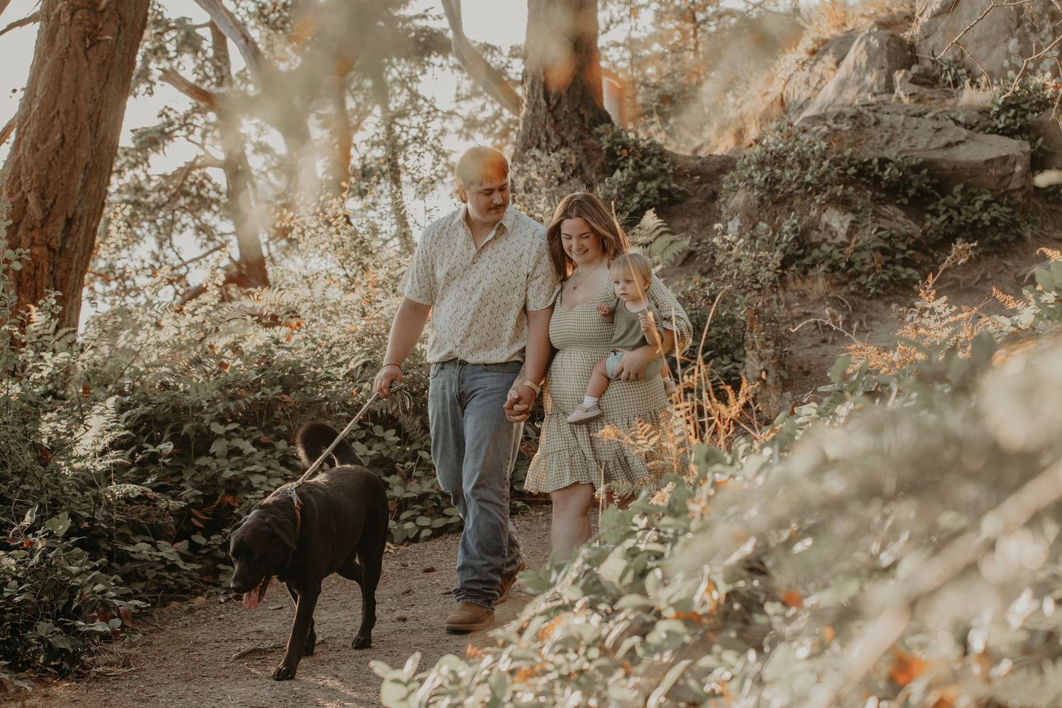 Two people walk through a beautiful forest path during golden hour as sunlight filters through autumn trees.