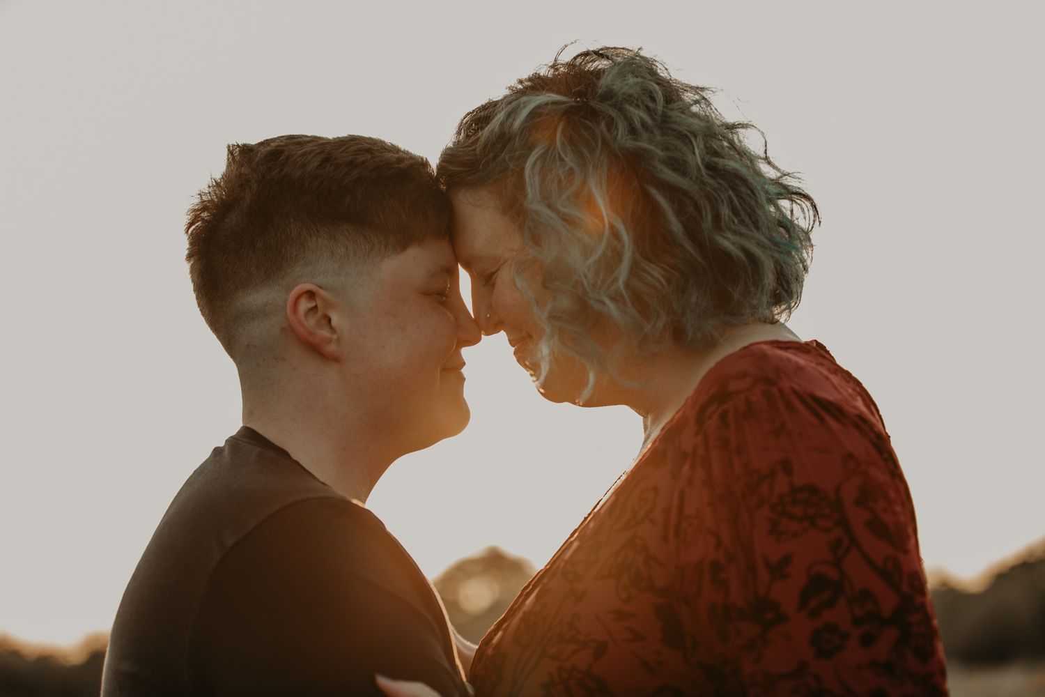 A romantic silhouette of a couple embracing against a warm sunset background.