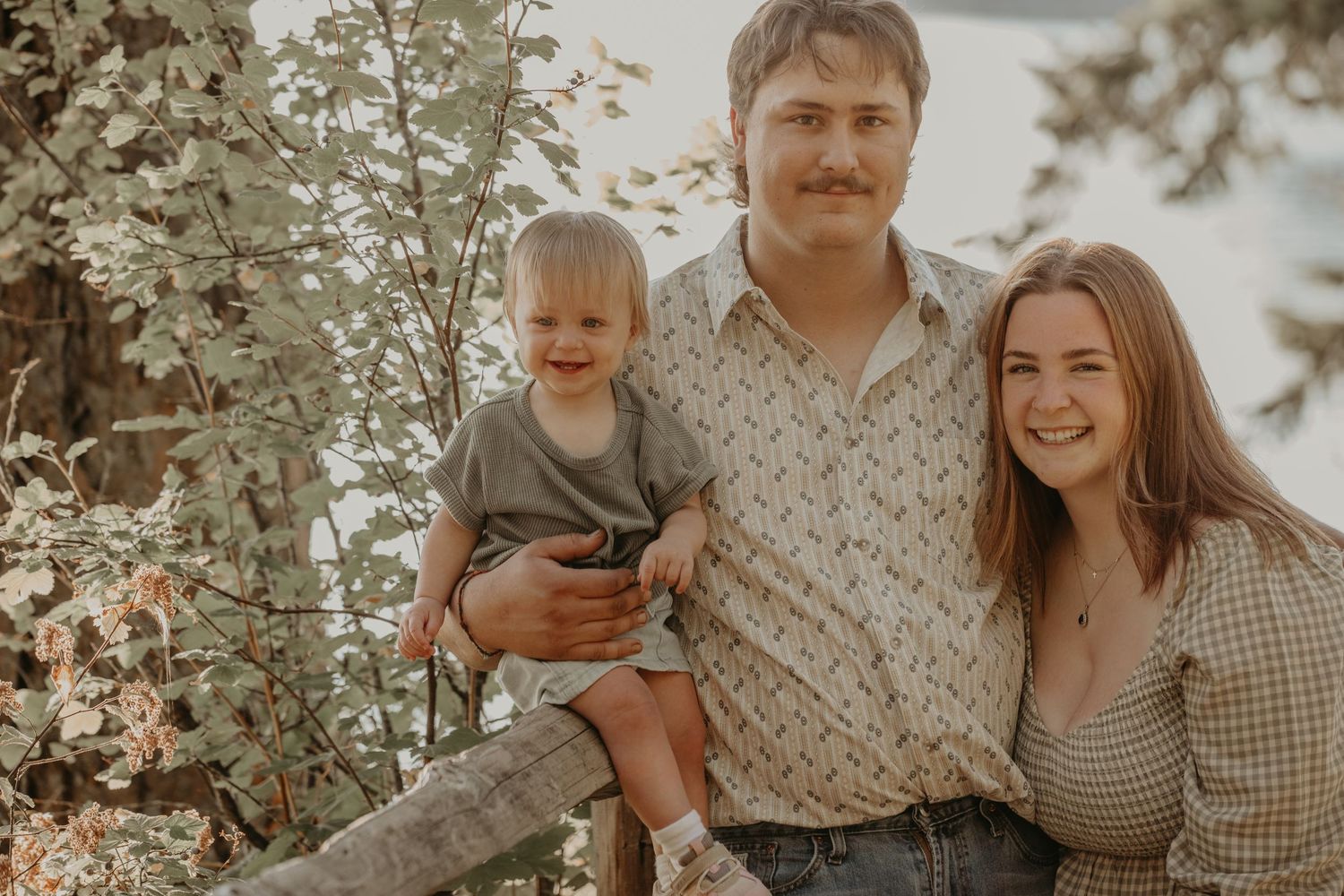 Family members sharing tender moments together in a dreamy outdoor setting with soft lighting.